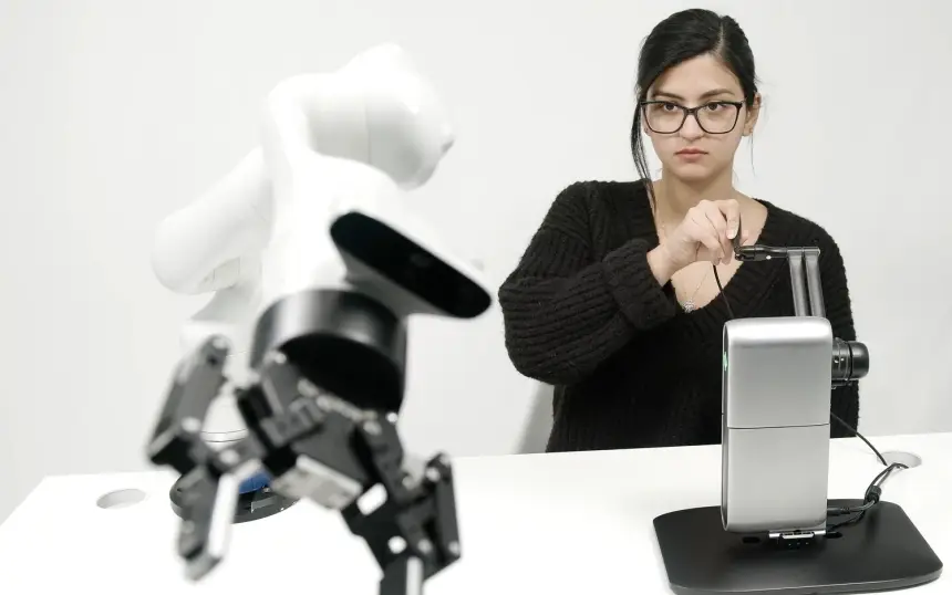 Operator guiding a robotic arm remotely with an Inverse3 haptic controller